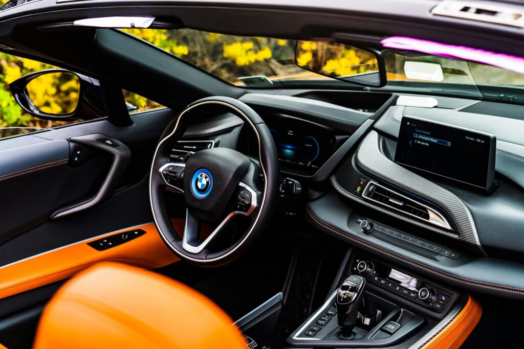 Sleek and modern BMW car interior showcasing a stylish steering wheel and digital dashboard.